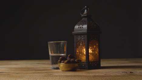 Tracking-Shot-of-Dates-Water-and-a-Lantern-On-a-Table