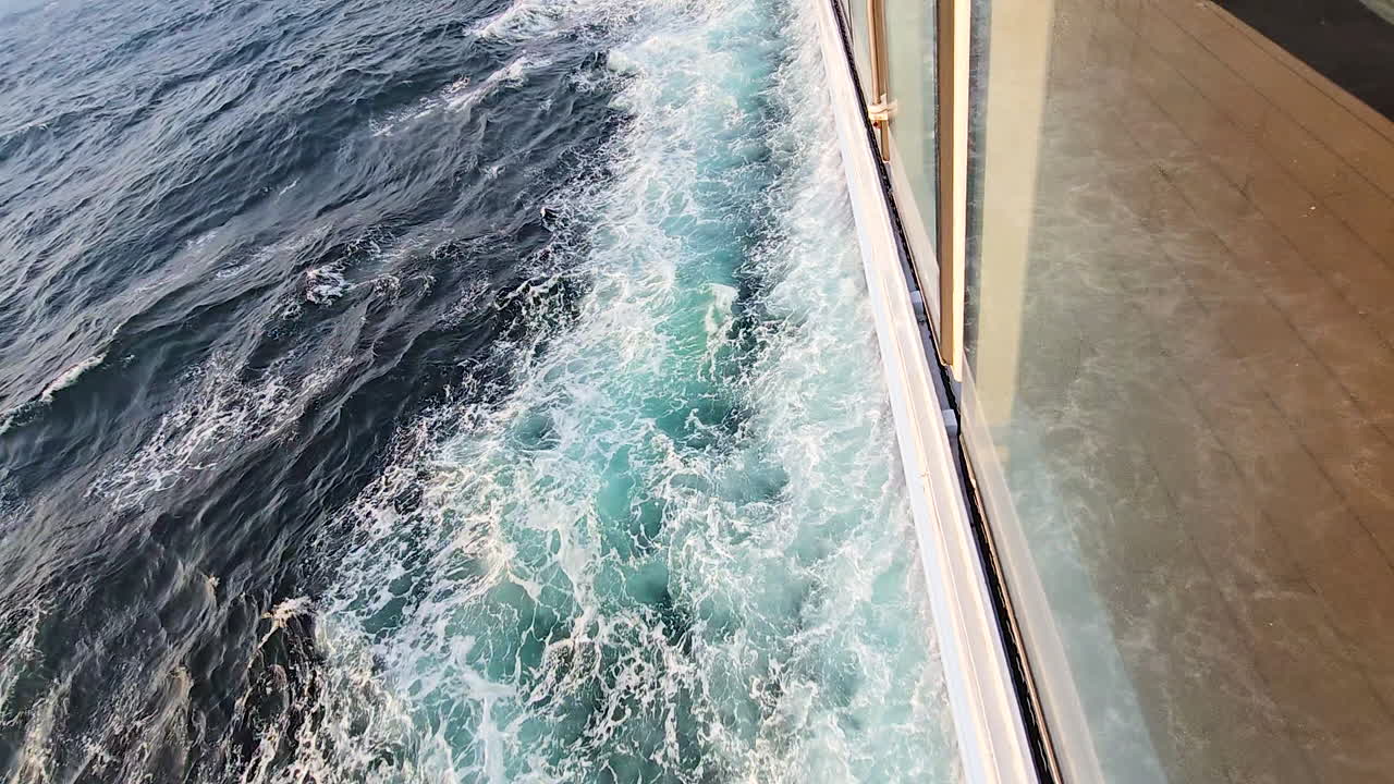 Fährfahrt, die weißes, schäumendes Wasser im Kielwasser des Ozeans aufwühlt, über das Meer fährt und Wellen und Turbulenzen hinterlässt, Reise von Osaka, Japan
