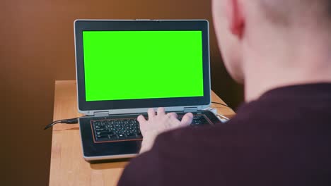 hombre trabajando en la computadora con pantalla verde