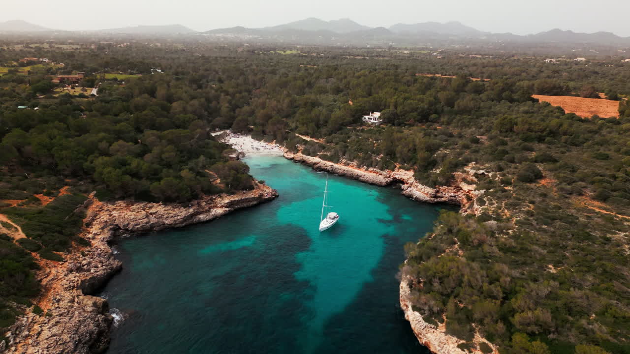 una vista aérea serena de un yate en la bahía de cala sa nau, mallorca