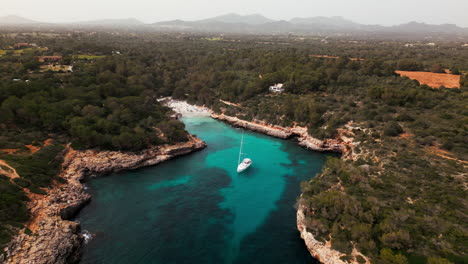 Serena-Vista-Aérea-De-Un-Yate-En-La-Cala-De-Cala-Sa-Nau,-Mallorca.