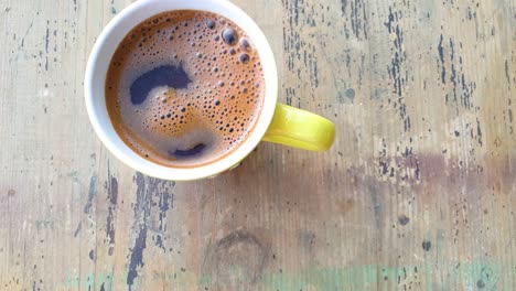 slow motion of cup of black coffee sitting on the old wooden table