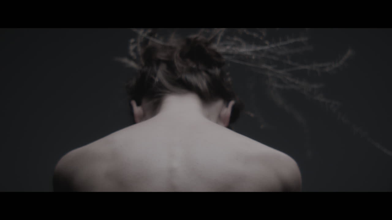 A woman dressed as mother nature shows her back