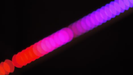 bokeh shot of defocused blurred christmas tree light that is blinking on black
