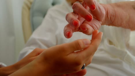 Close-up-of-Caucasian-senior-woman-showing-her-hands-to-female-doctor-at-home-4k