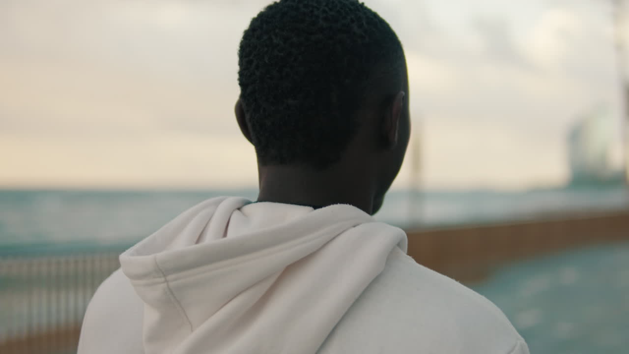 Young Black Man Standing by the Sea, Looking at the Horizon