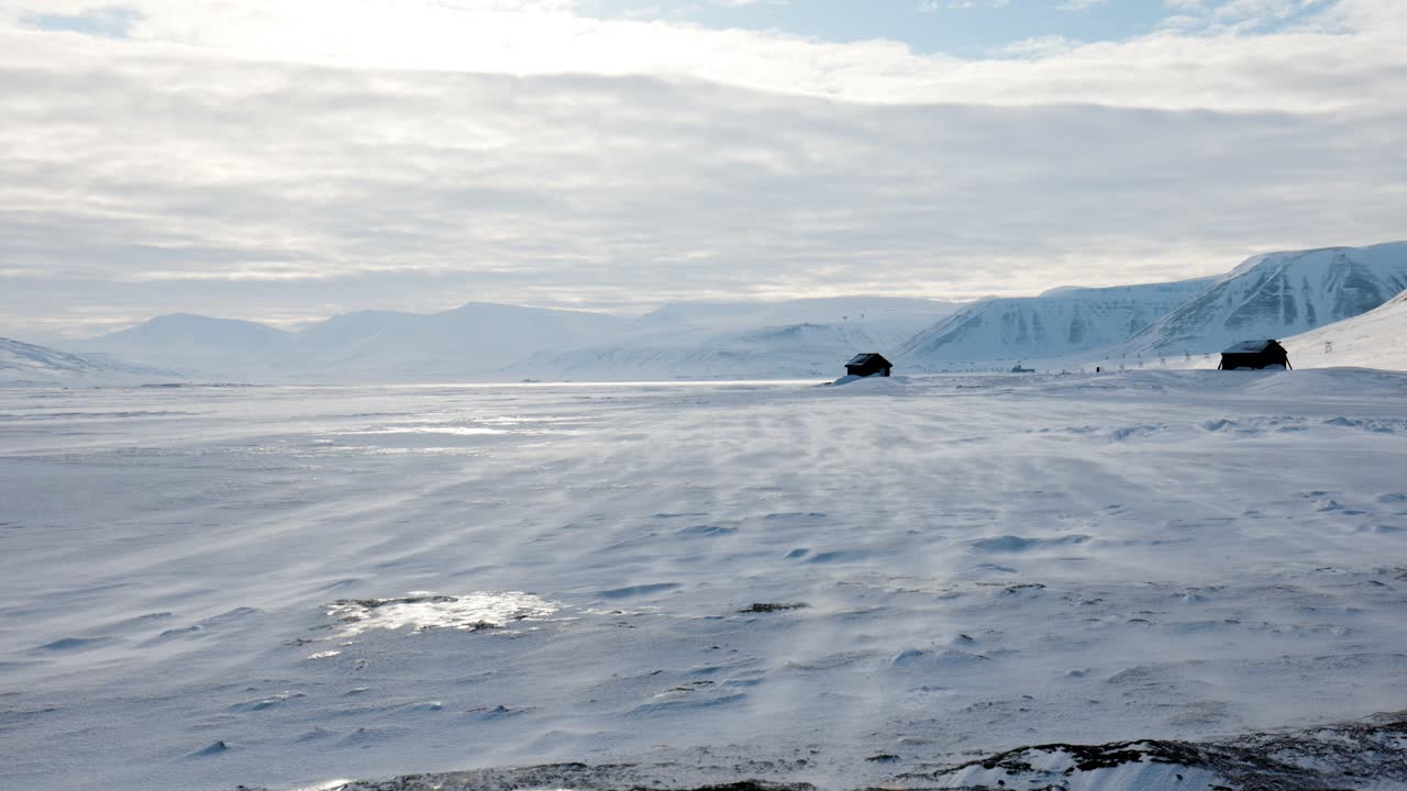 Snow drift across the arctic ice outside of the city of Longyearbyen in Svalbard. Static handheld shot.