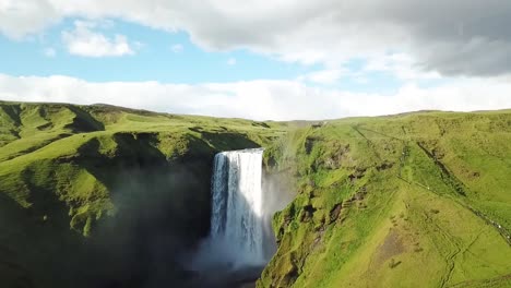 Eine-Vorwärtsbewegungsaufnahme-Des-Skogafoss-wasserfalls-In-Island-Mit-Möwen,-Die-Bei-Sonnenuntergang-Um-Ihn-Herumfliegen