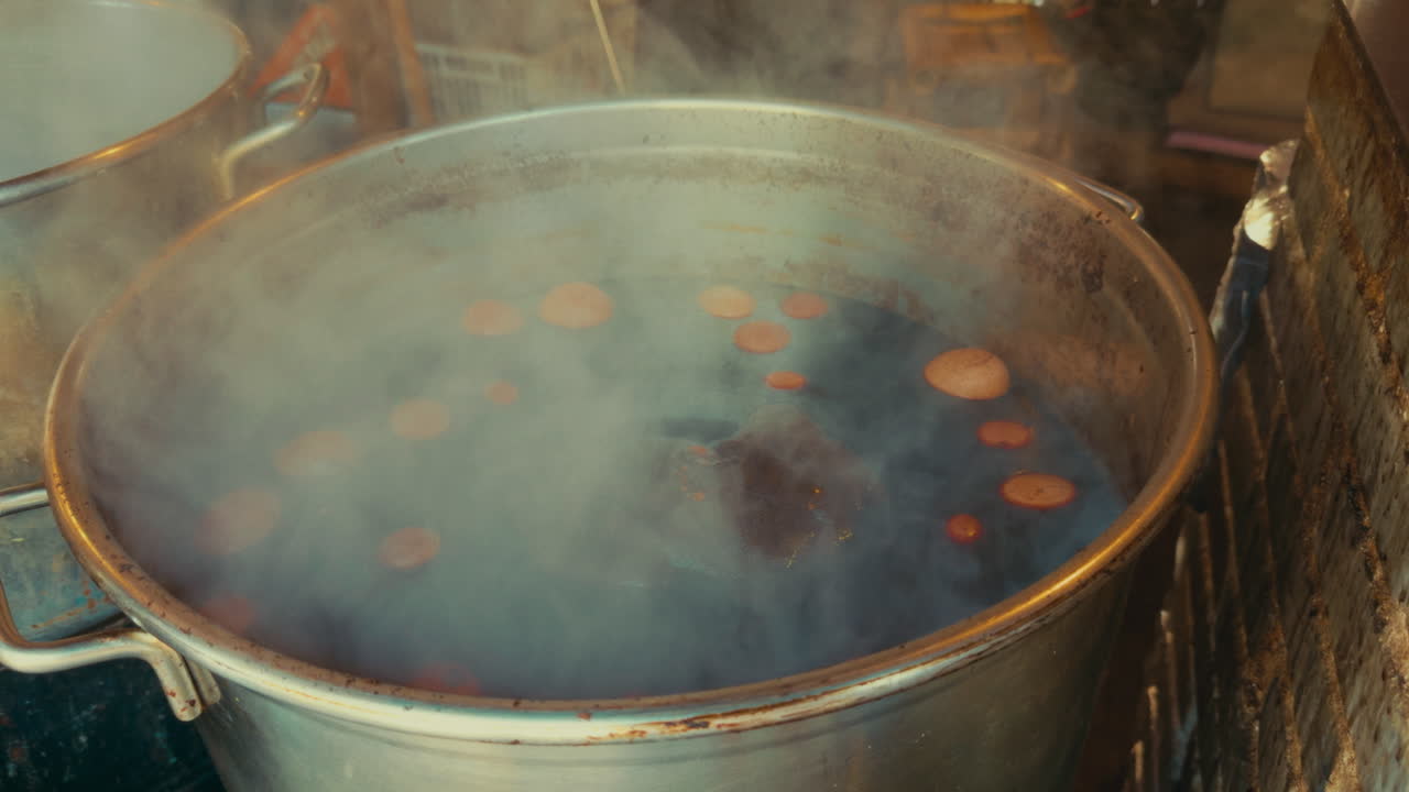 Boiling ingredients in a large pot with steam rising in a market setting, Wuzhen, China