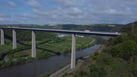 aerial trucking shot of moselle bridge in winningen during sunny day with traffic in germany