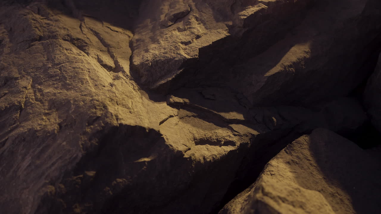 Close up detail of rugged rocks with glistening water, capturing intricate textures under dusk light