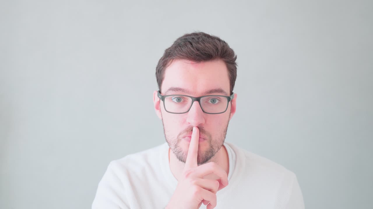 Joven con el dedo delante de la boca, señal de secreto y calma, mantén el secreto, no digas nada, no hagas ruido, guarda silencio.