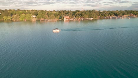 Aerial-beach-town-of-Bacalar-Mexico-resort-in-seven-colours-lagoon-with-sailboat