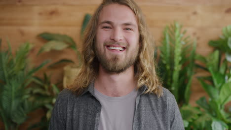 portrait of handsome young man smiling happy enjoying successful lifestyle blonde caucasian male with long hair slow motion