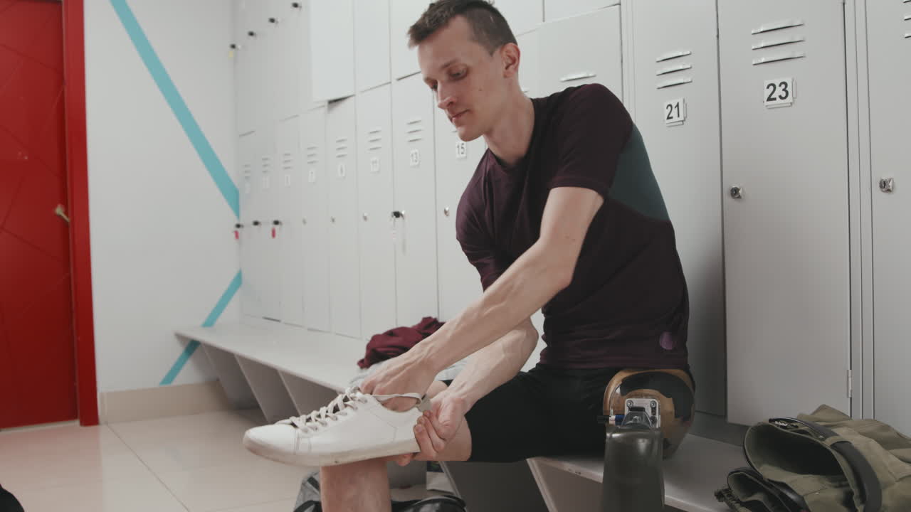 Sportsman Putting On Robotic Leg Before Training