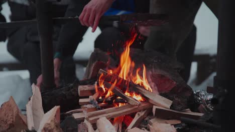 anonymous people gathering around campfire