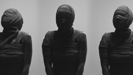 mummies on a white backdrop slowly rise their heads and look around