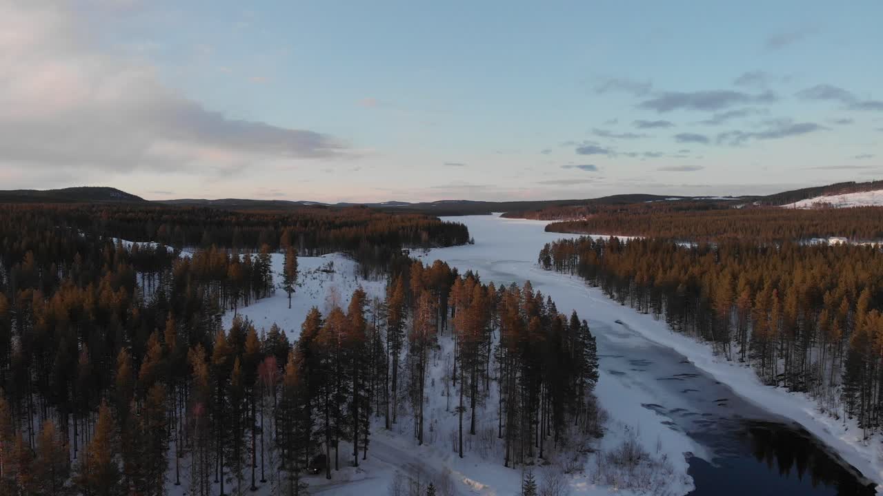 Breathtaking aerial shot of snowy nature near Lycksele, Sweden. Shot on a drone camera dolly in above forest. Showcasing the calm and beautiful landscape of Sweden and clear sky.