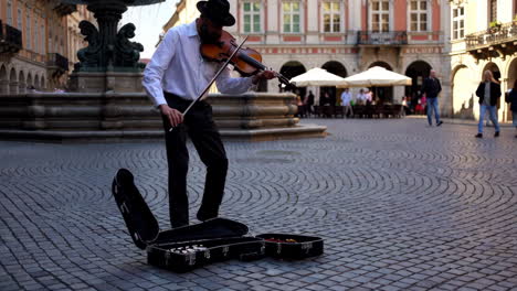 european city square with cafes and street musician