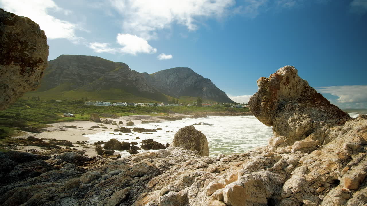 vista a través de formaciones rocosas únicas de la costa de hermanus con la montaña en el fondo