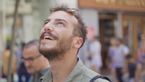 un jeune homme excité et joyeux regardait autour de lui dans la foule.