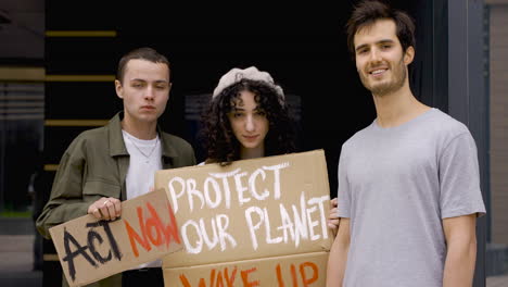 three friends holding and showing boards before the protest