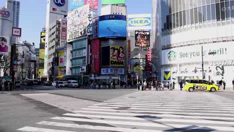 pedestrians and vehicles crossing a busy urban intersection