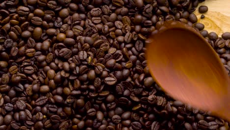 4k imágenes. 4096x2304p. granos de café perfumados son asados en una sartén, el humo proviene de los granos de café. toda la composición se desplaza lentamente alrededor de la cámara. cucharada agitar granos de cafe.