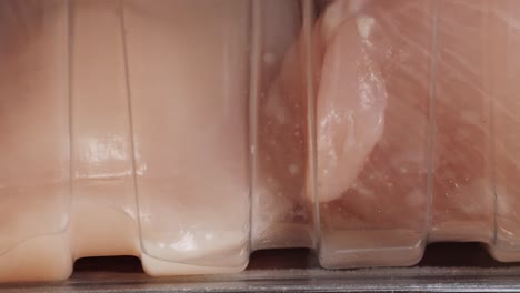 raw chicken breast in plastic packaging