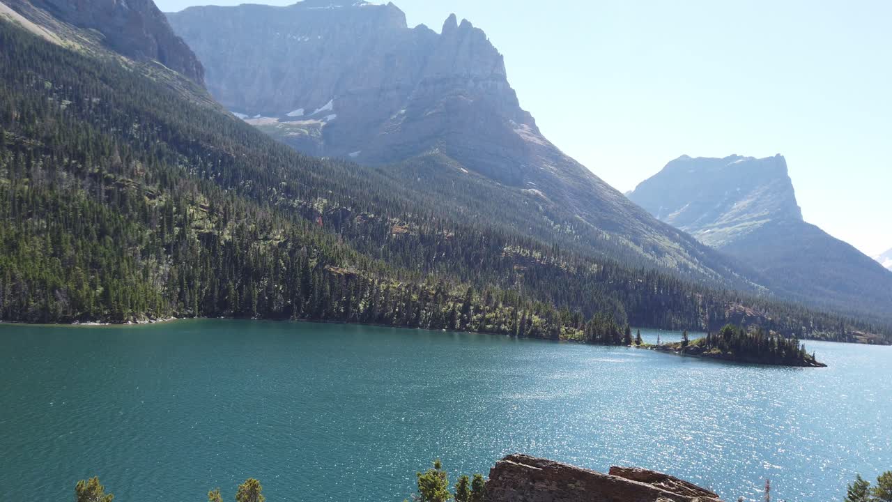 lago rodeado de montañas en el parque nacional de los glaciares, horario de verano, visita montana