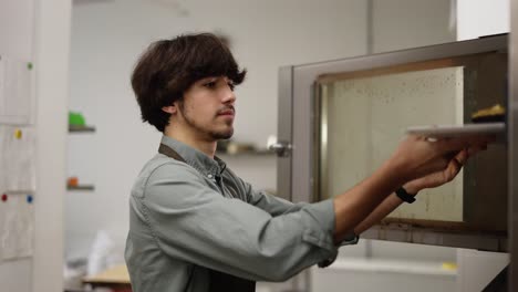 Cocinero-Masculino-Abriendo-El-Horno-Y-Poniendo-Pastel-Crudo-En-La-Cocina.-Concepto-De-Preparación-De-Alimentos.-Camara-Lenta