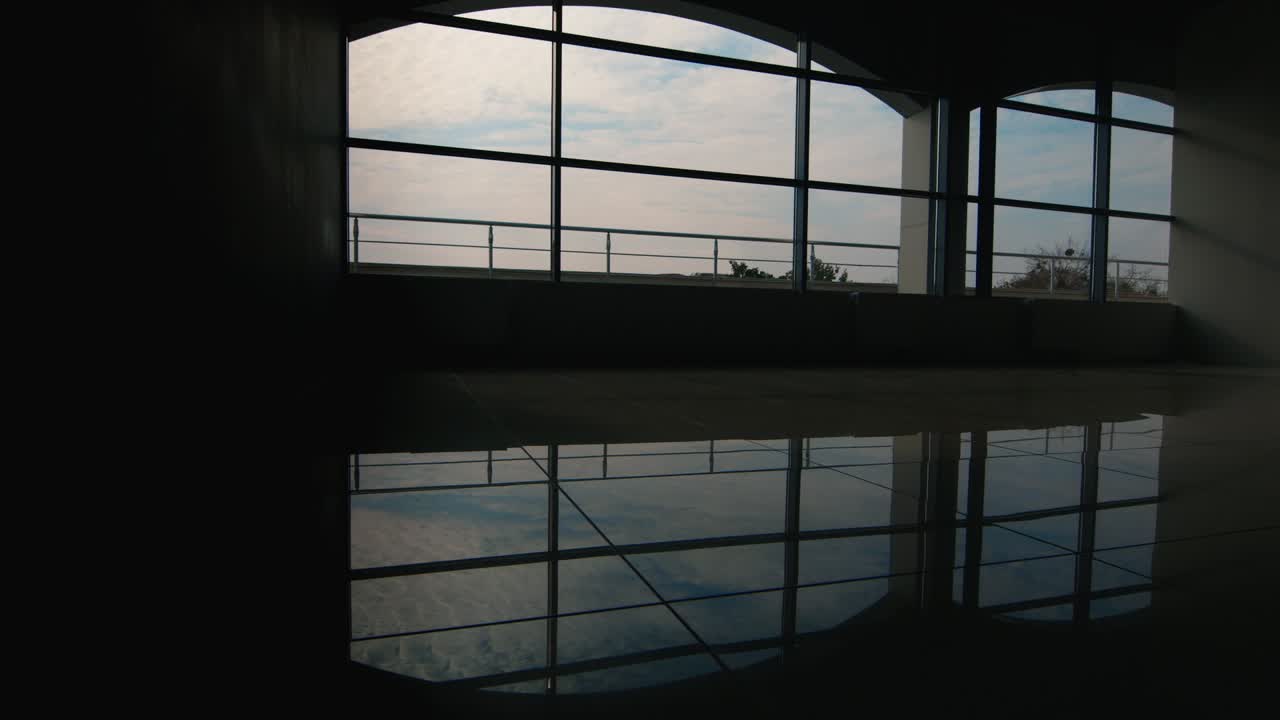 두 사업가의 실루엣이 창가의 넓은 홀에서 만납니다.