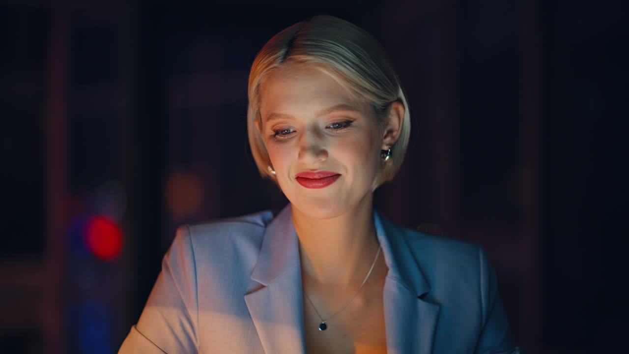 Portrait businesswoman working late evening at dark apartment. Smiling blonde