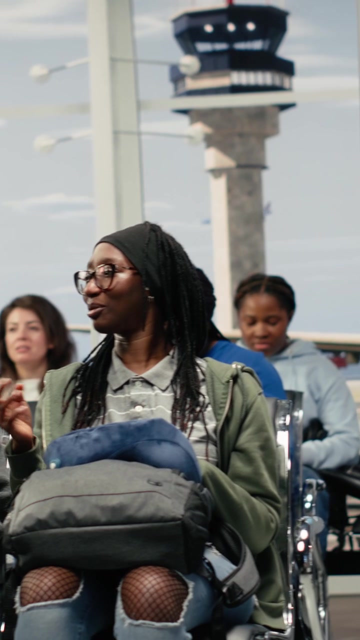 Vertical video Women in airport amused by army squad patrolling