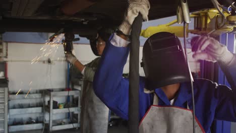 video de dos mecánicas de coches diversas soldando un coche