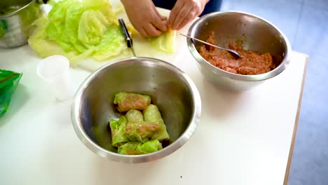 Persona-Preparando-Rollos-De-Col-Rellenos-En-La-Cocina---Primer-Plano,-ángulo-Alto