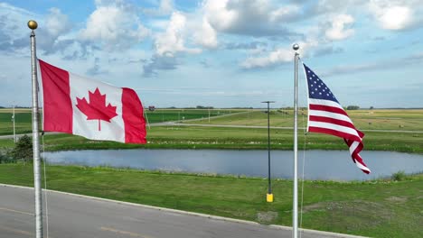 American-flag-and-Canadian-flag-waving-at-North-American-border-in-rural-area
