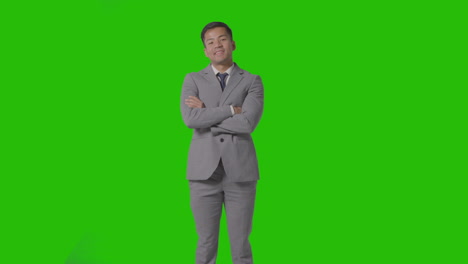 retrato de tres cuartos de longitud de un hombre de negocios en traje contra una pantalla verde sonriendo a la cámara 1