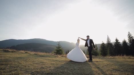 newlyweds. caucasian groom with bride walking on mountain slope. wedding couple