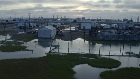 Aerial-Drone-shot-Flying-over-Flooding-Climate-Research-Center-in-the-Thawed-Permafrost-Tundra-with-Arctic-Ocean-in-Background-near-Barrow-Alaska