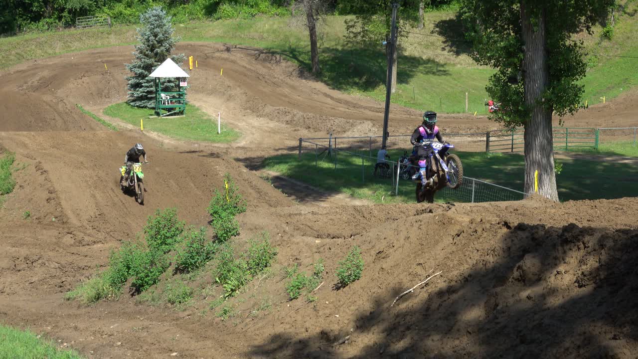 Pilotos de motocross pulando e correndo em uma pista de terra