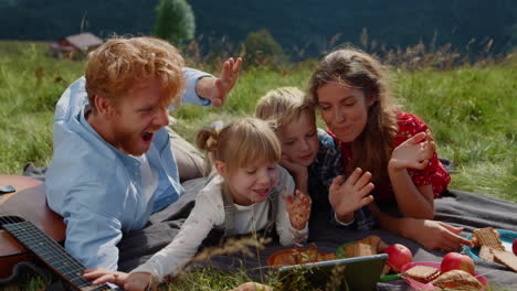 eine familie spricht online über die natur mit einem tablet in der nähe. menschen winken mit den händen.