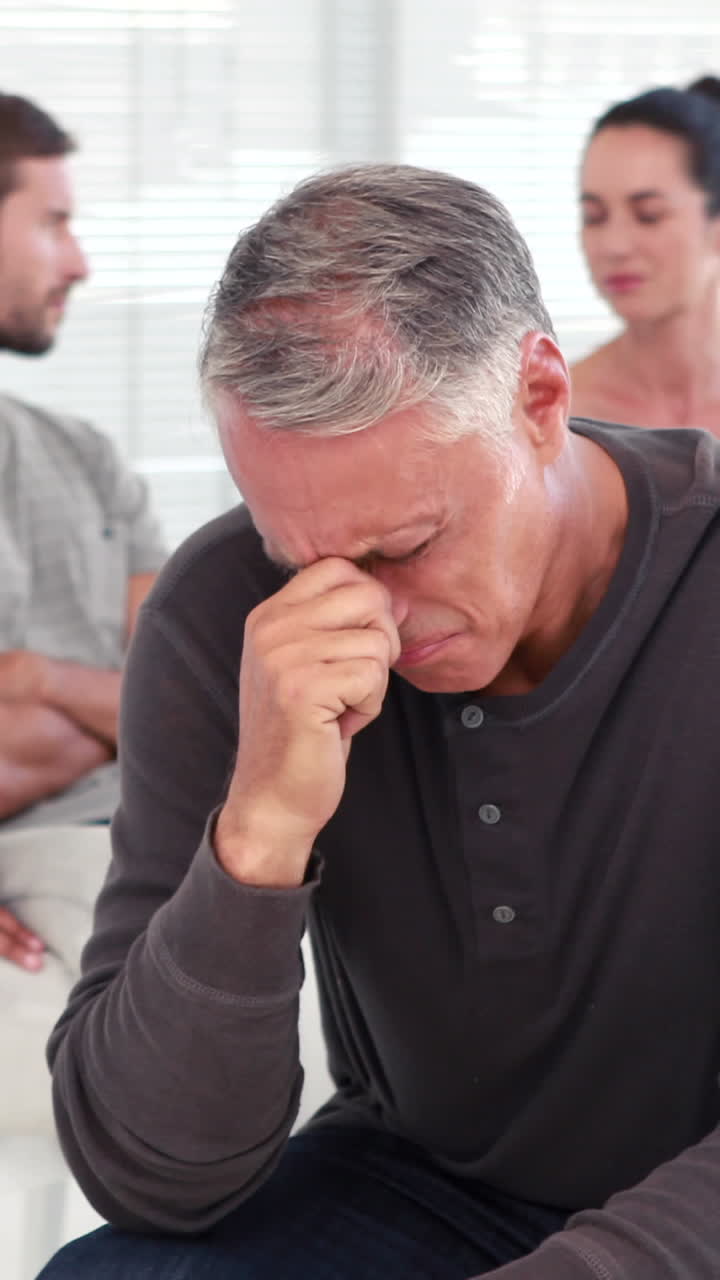 Uomo che conforta un altro nel gruppo di riabilitazione alla terapia