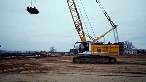 compactación dinámica del suelo: una grúa deja caer un peso pesado para compactar los cimientos en un sitio de construcción