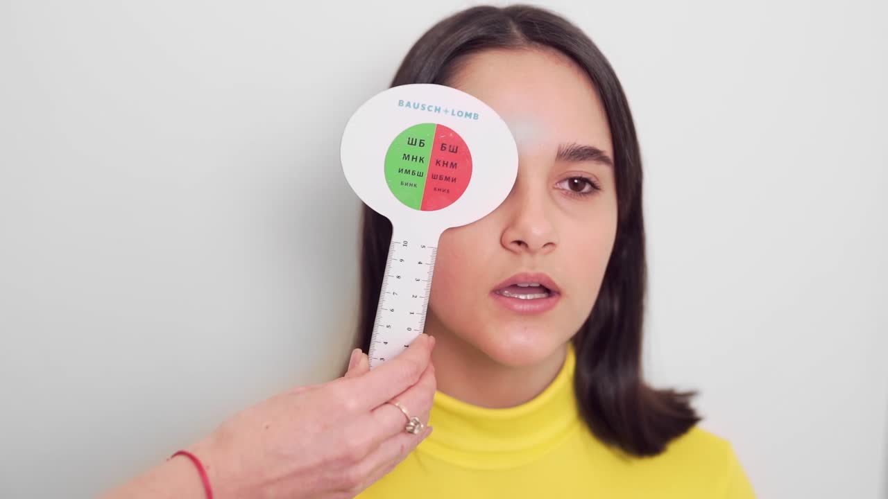 어린 소녀는 검안사에서 시력을 확인합니다.