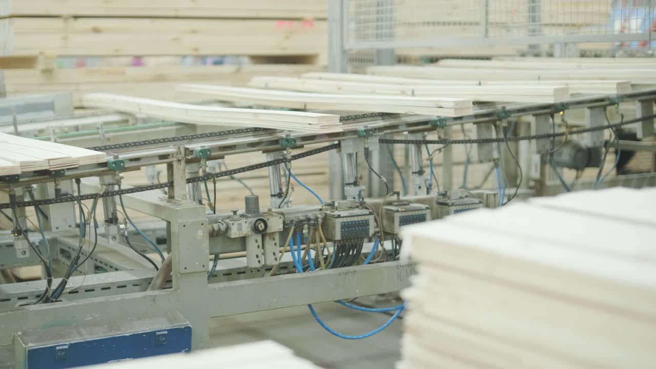 Industrial Worker Sorting Wooden Planks on a Production Line