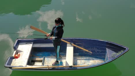 woman on the boat catches a fish on spinning in norway.