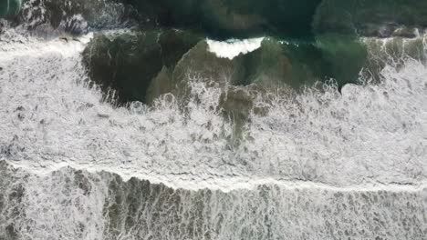 big waves swirl sand in the clear turquoise water on the sandy beach of rena majore