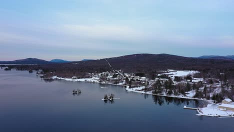 aerial footage flying towards some small snow covered islands on moosehead lake