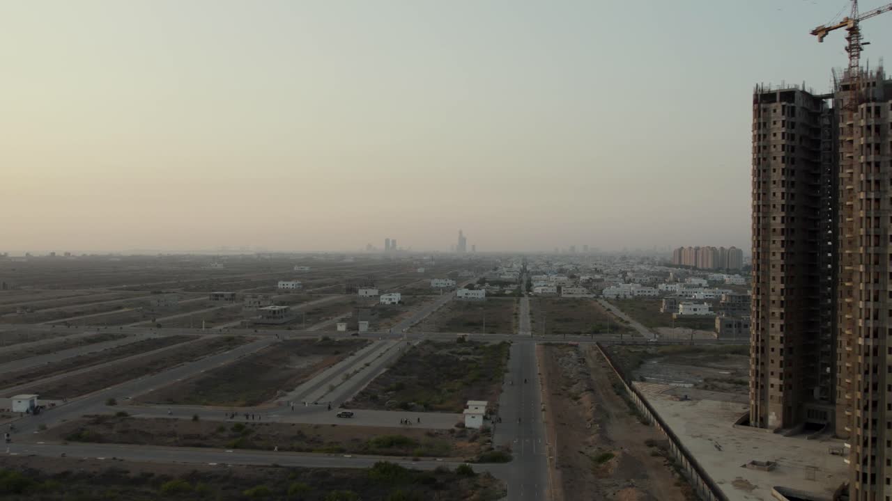 edificio de gran altura en construcción junto a parcelas urbanas no desarrolladas